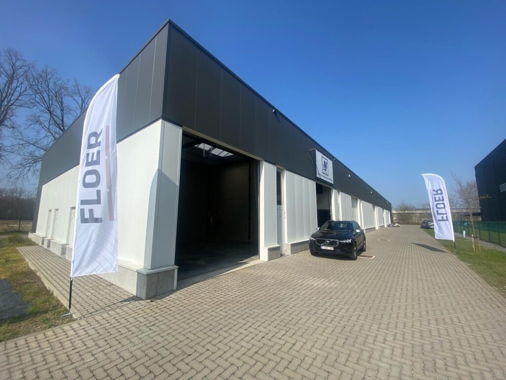 Het pand van MJ Vloer & Blind in Maaseik met Floer-vlaggen